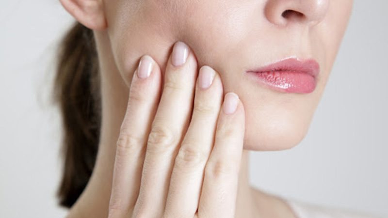 Studio shot of young woman with tooth pain, close up